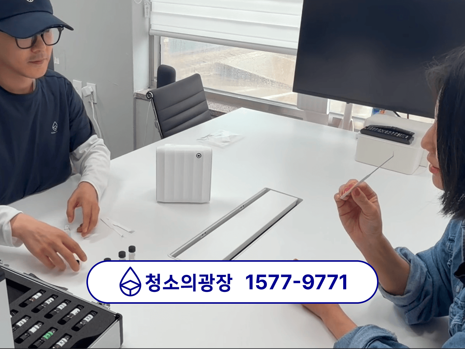 사무실 향기케어 진행을 위해 청소의광장 견적 담당자가 고객사 담당자에게 테이블에 앉아 시향 중인 모습