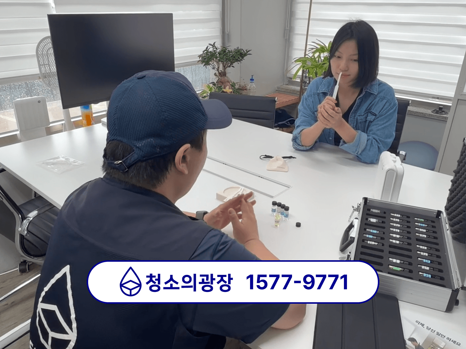 사무실 향기케어 진행을 위해 청소의광장 견적 담당자가 고객사 담당자에게 테이블에 앉아 시향 중인 모습