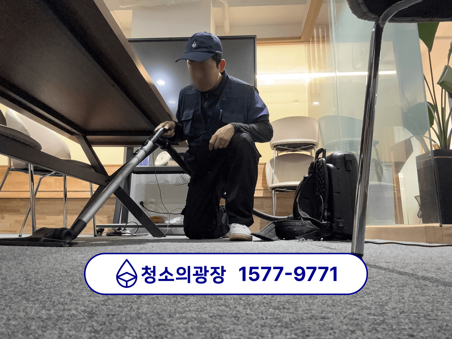 난방 전 사무실 대청소 중 회의실 테이블 아래 카펫을 청소하는 모습